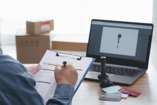 Staff check service list paper on the clipboard file and check coil spark plug gasoline engine part on the table and use laptop Inspect spare parts in stock before confirm the repair in service center photo