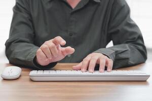 Business Man pushing on a touch screen interface action and keyboard mouse desktop on the table photo
