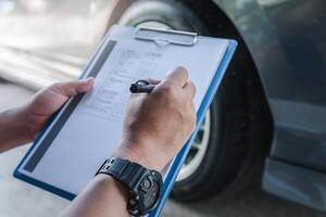 A man checklist in service cycle check of car and check tire air pressure data on paper check sheet basic maintenance concept of car photo