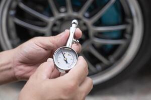 Home car basic check close up A man hold air pressure gauge check tire air pressure in service concept photo