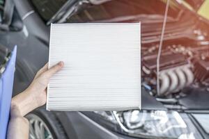 Employees women of the car service center checking filter cooling system and check list for maintenance concept of service car photo