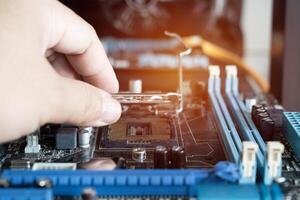 The technician is putting the Socket of old CPU on the motherboard for check and service photo