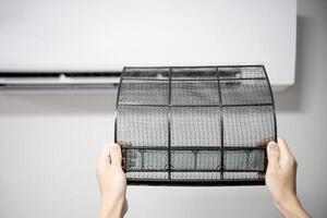 Women change air filter and Cleaning Air Conditioning System At Home basic and easy cleaning with home cooling photo