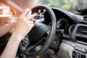 Women use Alcohol spraying clean steering wheel and inside car part cleaning concept with virus in transport photo