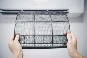 mujer cambio aire filtrar y limpieza aire acondicionamiento sistema a hogar básico y fácil limpieza con hogar enfriamiento foto