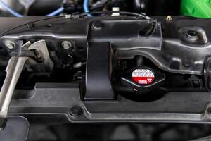 Radiator cap in engine room of gasoline engine car show warning messages on the safety cover for driver check before open in service concept photo