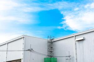 Wall storage warehouse and scaffolding for maintenance on the roof and blue sky background photo