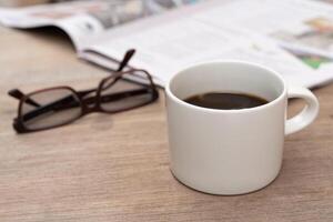 Close up coffee cup and newspaper on wood table Reading news in the traditional world no Social network photo