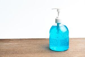 Alcohol gel in clear plastic Pump type bottles on the wood table and white background photo