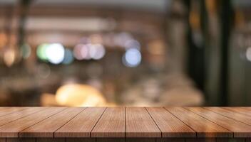 Empty wooden table top with lights bokeh on blur restaurant background photo