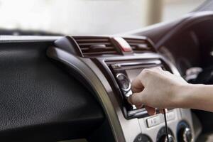 Hand a man plug in USB cable on the car audio use connecting data car play and music Navigation system in the car. photo