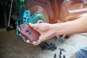 Home service car concept Close up hand a man Hold brake pads and applying Grease anti seize on the back brake pads in car caliper brake and check system in basic maintenance photo