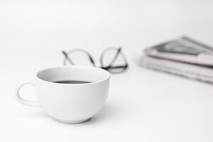 White coffee cup,glasses,News paper on the white table photo