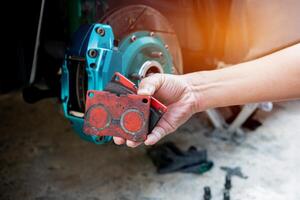 Hand a man remove brake pad from brake caliper thickness check and maintenance stop system of car photo