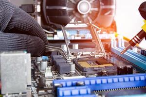 Electronic technician is putting the Socket of old CPU on the motherboard for check and service photo