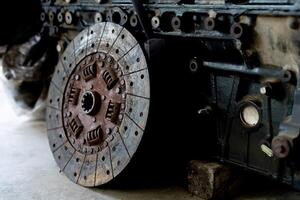 Old engine clutch disc of truck engine on the garage floor photo