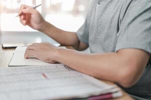 Men are reading newspapers to view daily news and information and writing pens in notebooks while working at home photo