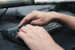 mano un hombre empujar conectar botón opción de computadora escritorio teclado para Seleccione dispositivo para trabajando en el mesa foto