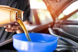 A man Refueling and pouring oil Adding engine oil in engine motor car maintenance Energy fuel concept photo