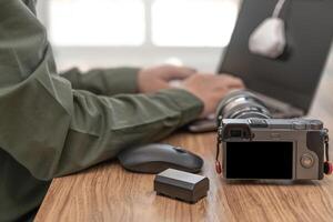 Close up camera with photographic equipment on the table and a man display calibration for monitor standard in photographic work photo