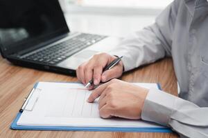 Business man working and analyzing on document data graph with laptop computer calculate for new project of business strategy at workplace. photo