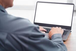 Close up view of Business man working analyst of work on laptop while sitting at wooden table. Business man analyze stock report on notebook screen photo