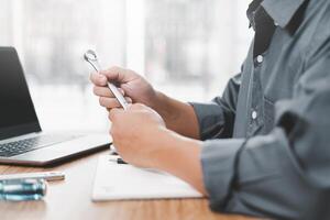 el técnico sostener un llave inglesa en mano y usado un computadora ordenador portátil a analizar el roto de coche en Servicio habitación concepto foto