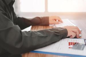 hombre utilizar computadora escritorio para oficina trabajo y crédito tarjeta y documento en mesa foto