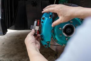 A man setting part of brake caliper in service work he change brake pad in garage photo