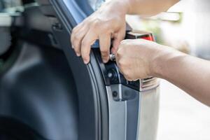 Close up hand a man use block wrench remove bolt of car tail lights are being disassembled with the car body Maintenance of lighting systems for safety concept photo