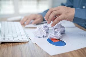 Crumpled papers on table with a man strain feeling was frustrated with working failed in work office photo