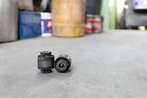 Old Rubber bush and joint component part of car suspension on service shop floor change and maintenance in service process photo