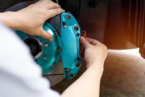 Man remove brake pad in brake caliper for thickness check of pad in service work photo