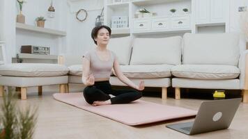 une jeune femme asiatique s'entraîne sur un tapis de fitness, fait de l'exercice à la maison, concept de mode de vie sain video