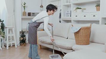 content asiatique Jeune femme balayage le sol à nettoyage loger, en bonne santé mode de vie concept video