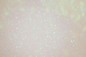 Beige background with green defocus lights. Abstract glitter background. Bokeh photo