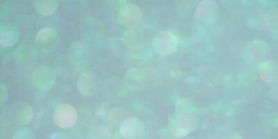 Abstract background of blue and green glitters defocus. Banner size blue bokeh. photo