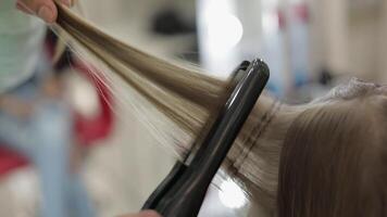 professionnel coiffeur travail avec modèle cheveux. redressage ondulé le fer video