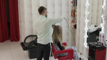 professionale parrucchiere Lavorando con modello capelli. raddrizzatura ondulato ferro video