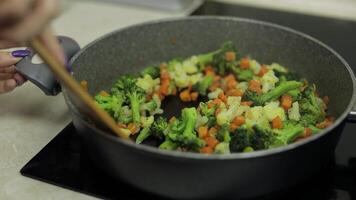 mistura fresco legumes em fritar frigideira. ebulição cenouras, couve-flor, brócolis video
