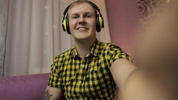 POV handheld shot of young man making selfie, talking, video call at home