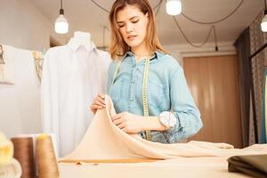 Portrait of beautiful attractive woman, red hair, smiling, happy. Professional seamstress, female strength, businesswoman. woman power. work process. photo