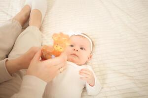 mother plays with newborn baby photo