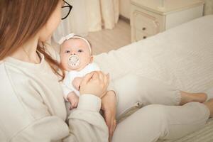 mother plays with newborn baby photo