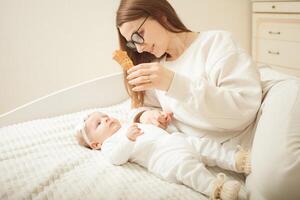 mother plays with newborn baby photo