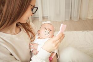 mother plays with newborn baby photo