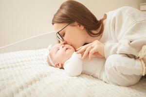 mother plays with newborn baby photo