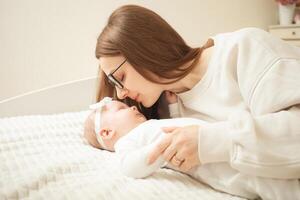 mother plays with newborn baby photo