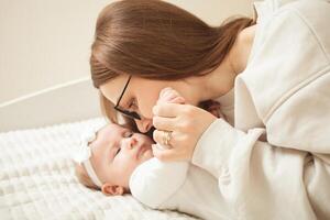 mother plays with newborn baby photo