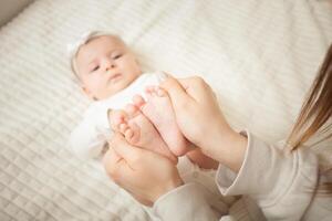 mother plays with newborn baby photo